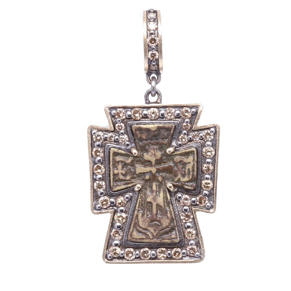 This small sized antique Russian Orthodox Cross pendant has a beautiful brown patina from oxidizing overtime. On the back of the medal is a Maltese Cross. The original medal is set in a 14k Yellow Gold 3.77g, Diamond 1.12 tcw, and Rhodium Sterling bezel. Antique Russian Orthodox Cross Pendant
