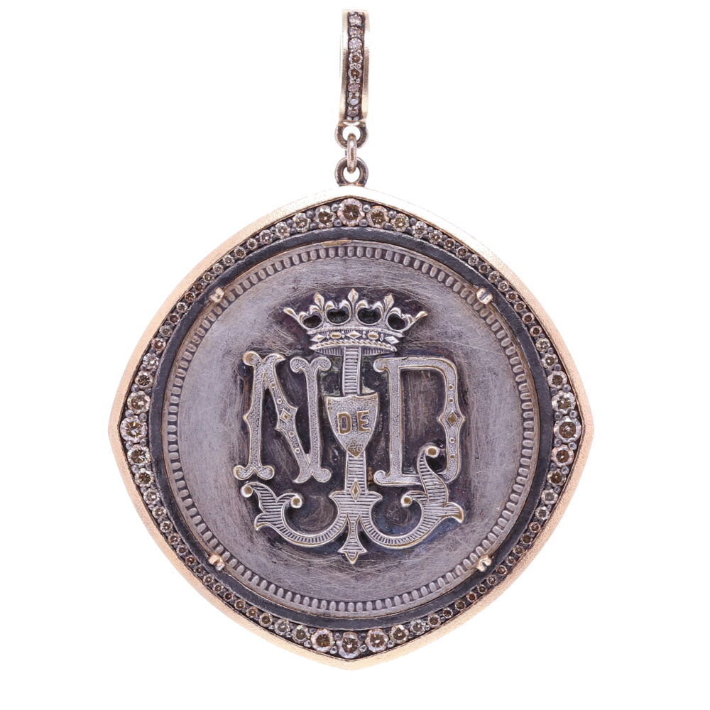 This antique French Notre Dame pendant displays the iconic logo on the front. The Mariner's cross is shaped like an anchor, it symbolizes a 'Fresh Start' or 'Hope'. The medal is surrounded by a unique diamond bezel. The back of the pendant has three Fleur De Lis referring to the Holy Trinity. A Fleur De Lis is a stylized lily flower composed of three petals bound together. The symbol represents the Holy Trinity and is the symbol of Virgin Mary. This antique medal is set in a 14k Yellow Gold 4.1g, Diamond 1.31tcw, and Rhodium sterling bezel. The bale when opened is 4mm. French Notre Dame Medal with Mariner's Cross