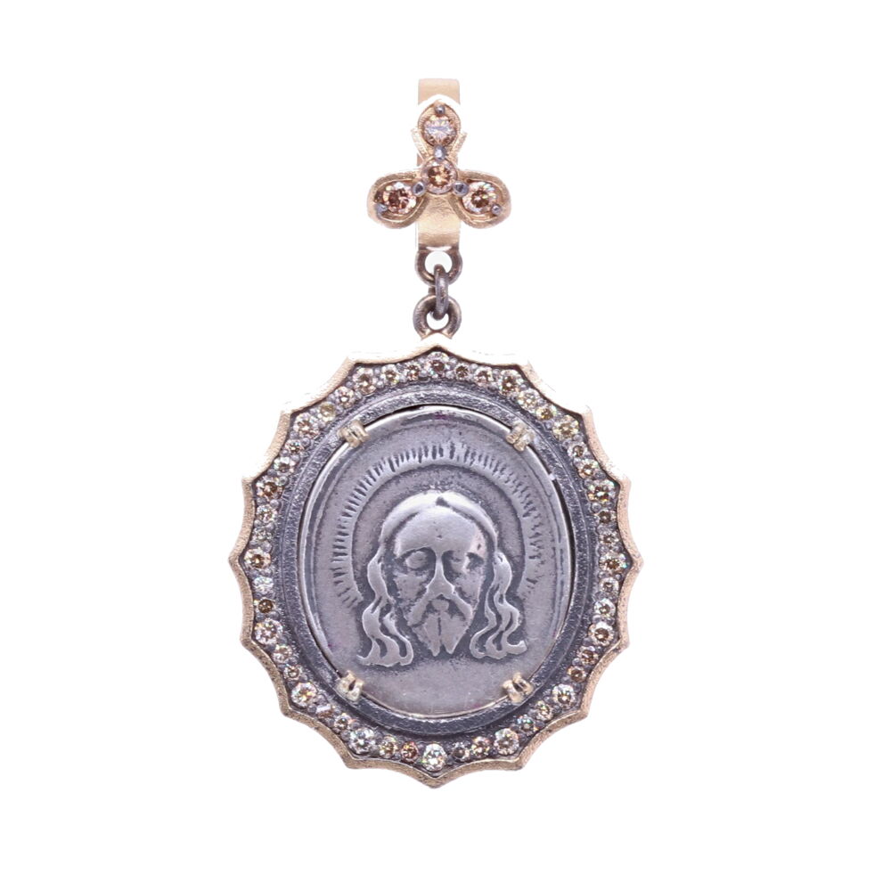 This original 19th Century medal displays Christ on the front and The Lady of Guadalupe on the back. This medal is set in a 14k Yellow Gold 3.1g, Rhodium sterling, and Diamond 0.66 tcw bezel.The bale opens to 4mm. Spanish 19th C. Christ and Lady of Guadalupe Pendant
