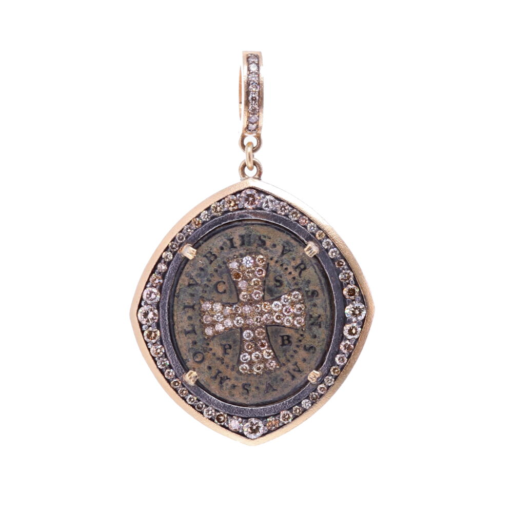 This original St. Benedict artifact medal is set in a Cynthia Ann bezel. The medal is surrounded by a unique gold 3g and diamond bezel 1.47 TCW. The bale has a 4mm opening, which can clip onto any necklace. Carrying a St. Benedict coin provides the highest amount of protection from evil. On the front, the medal has a cross with diamond inlay, it's the sign of our redemption. The large CSPB on the front stands for "The Cross of our Holy Father Benedict".V R S N S M V - S M Q L I V B on the front translates to "Begone Satan! Never tempt me with your vanities! What you offer me is evil. Drink the poison yourself!" The back of the pendant St. Benedict is holding a cross in his right hand (his devotion) and his left hand is his rule for monasteries. The medal has an original green patina from oxidizing over time. St. Benedict Artifact Pendant