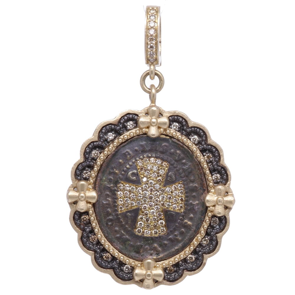 To this day, after 1,400 years after his writing, the St. Benedict Rule is the most common and influential Rule used by monasteries and monks. Carrying a St. Benedict medal provides the ultimate protection from evil. It is one of the oldest and most honored medals used by Christians. The front and center of the medal the monogram "CPSB" stands for the Cross Of Holy Father Benedict. At the top of the medal "IHS" Jesus. Around the cross "V R S N S M V - S M Q L I V B" Begone Satan! Never tempt me with your vanities! What you offer me is evil. Drink the poison yourself! This original one of a kind antiquity is set in a 14k yellow gold 7.06g, champagne diamond 0.52tcw, and rhodium sterling bezel. Cynthia Ann enhanced this medal with diamond shield cross inlay. The brown patina is original. St. Benedict Diamond Shield Pendant