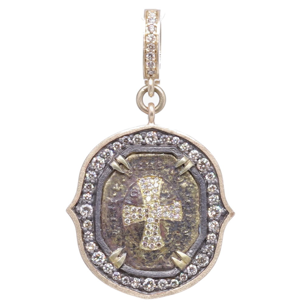 This small sized St. Benedict medal is the size of a dime. The top of the medal displays IHS or Jesus's monogram. The large CSPB stands for "The Cross of Holy Father Benedict". Cynthia Ann created a diamond inlay shield inside the CSPB. The exterior of the medal V R S N S M V - S M Q L I V B on the front translates to "Begone Satan! Never tempt me with your vanities! What you offer me is evil. Drink the poison yourself!". This medal is set in a diamond 0.78 tcw, rhodium sterling, and 14k yellow gold 2.95g bale. St. Benedict Cross Shield Pendant