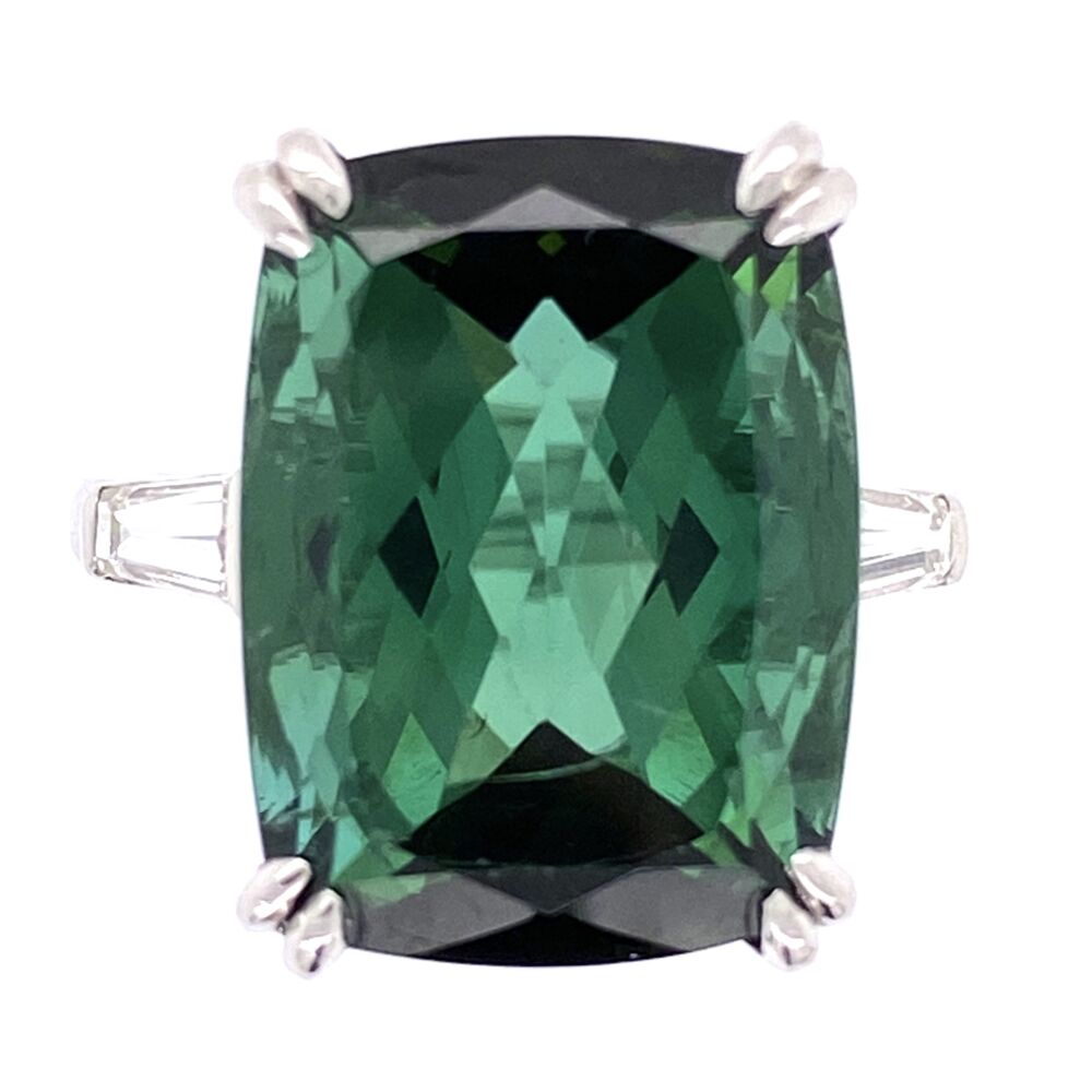 This gorgeously vintage ring comes in Platinum, with a 12.26 rectangular cut green tourmaline. This gorgeously green stone features 2 baguette diamond on either side of the center set stone, making it look like part of the band. The total diamond weight is .30 carats. This ring would make quite a statement when paired with anything in your closet. Platinum Rectangular Cut Green Tourmaline Ring