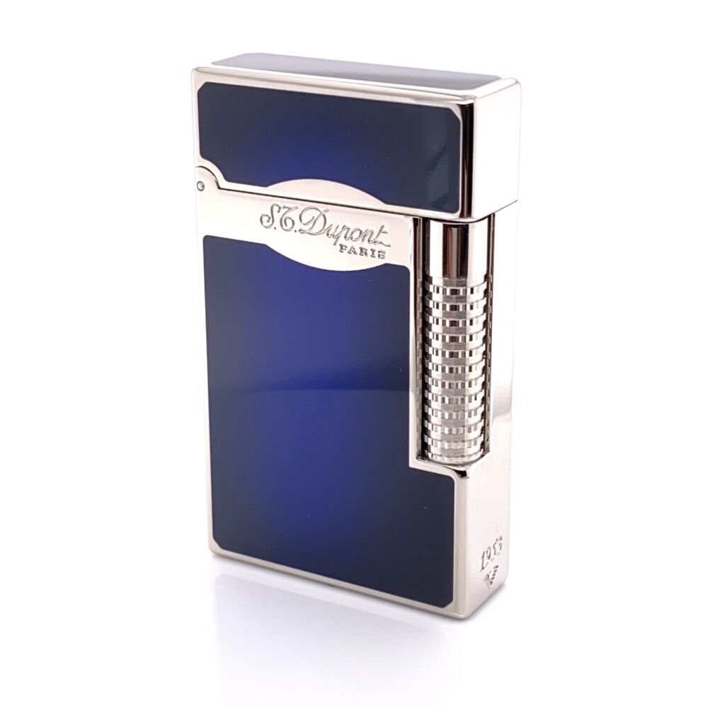 This Le Grand Cigar Lighter from S.T. Dupont is an excellent addition to any cigar enthusiast's collection, with a vibrant sunburst blue finish and palladium plated accessories and trigger mechanism. The guilloche roller allows for personal adjustment of flame strength. Simply flip the cap and light your cigar up perfectly every time. Slightly larger than the Ligne 2. <i>S.T. Dupont</i> engraved in front.<div><br></div><div>Dimensions: 1.54 x 2.6 x 0.55</div><div>Weight: 1lb</div> S.T. Dupont Le Grand Sunburst Blue Finish Cigar Lighter