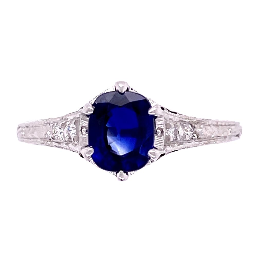 This ring has a vintage style using a cast method with diamonds, engraving and a beautiful center cushion shape 1.18ct blue sapphire. It is accented with milgrain, filigree and engraving 18K WG 1.18ct Sapphire & .06tcw Diamond Ring, s7