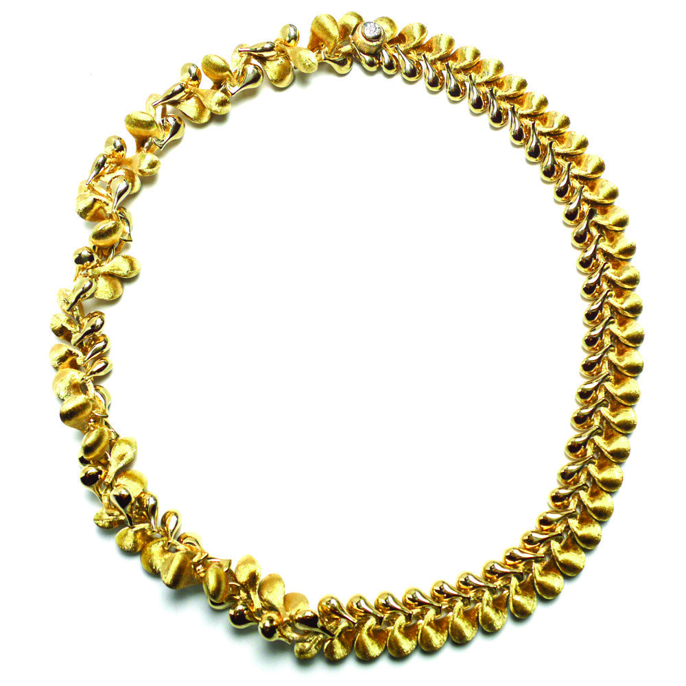 This truly alluring 18K yellow gold necklace brought to you by Nanis Fine Jewelry and Italian designer Laura Bicego brings style and sophistication. A wide link collar necklace that transforms into floral loose link collar, its clasp is set with 0.06 carat white diamonds. Transformista Floral Necklace