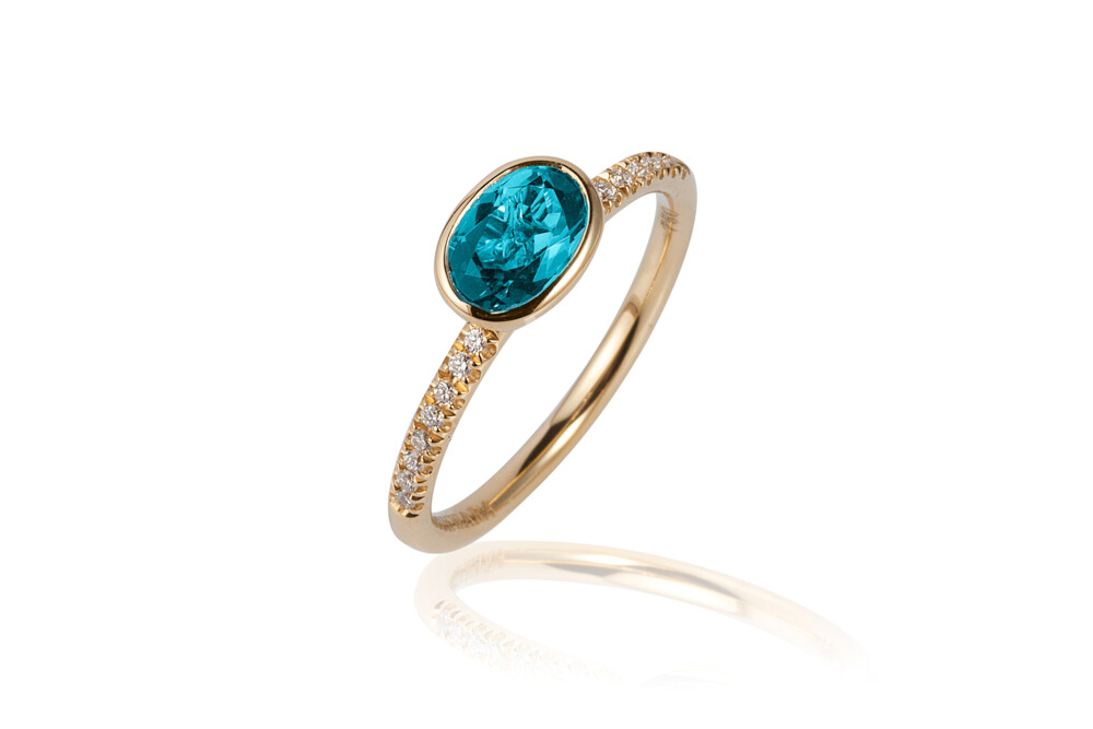 This absolutely beautiful 18K yellow gold stackable ring brought to you by Goshwara and designer Sweta Jain brings genuine elegance. It features 7x5mm faceted, oval-shaped blue topaz (0.94 carats) and 0.10 carat diamonds. Gossip Blue Topaz Ring
