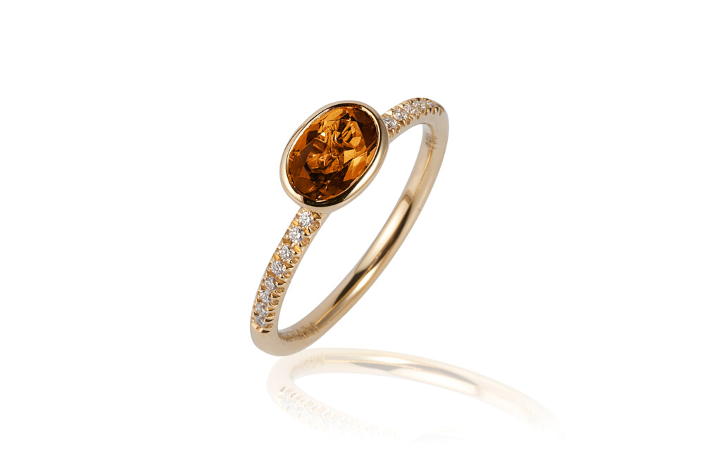 This absolutely beautiful 18K yellow gold stackable ring brought to you by Goshwara and designer Sweta Jain brings genuine elegance. It features 7x5mm faceted, oval-shaped citrine (0.73 carats) and 0.10 carat diamonds. Gossip Citrine Ring