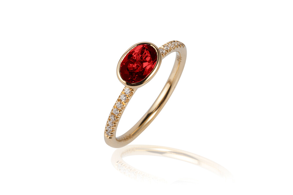 This absolutely beautiful 18K yellow gold stackable ring brought to you by Goshwara and designer Sweta Jain brings genuine elegance. It features 7x5mm faceted, oval-shaped garnet (1.06 carats) and 0.09 carat diamonds. Gossip Garnet Ring