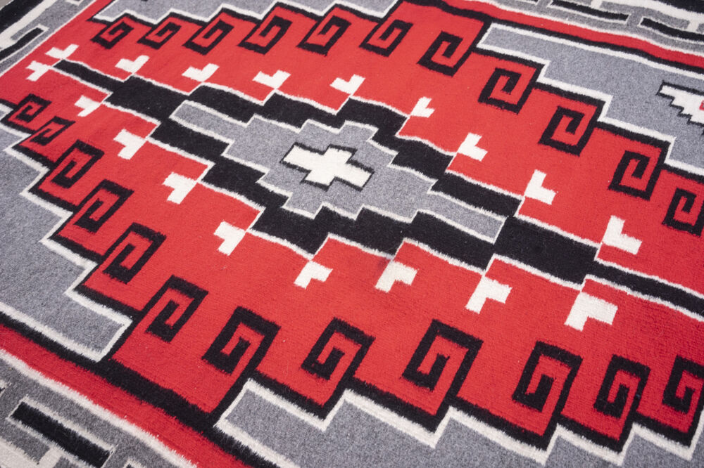 Part of Ken Johnson's collection of Navajo rugs, Granado Red features a red ground with a black border enclosing a black, grey and bone patterned border and black, grey and bone design at its center. Rug Cn12 Granado Red