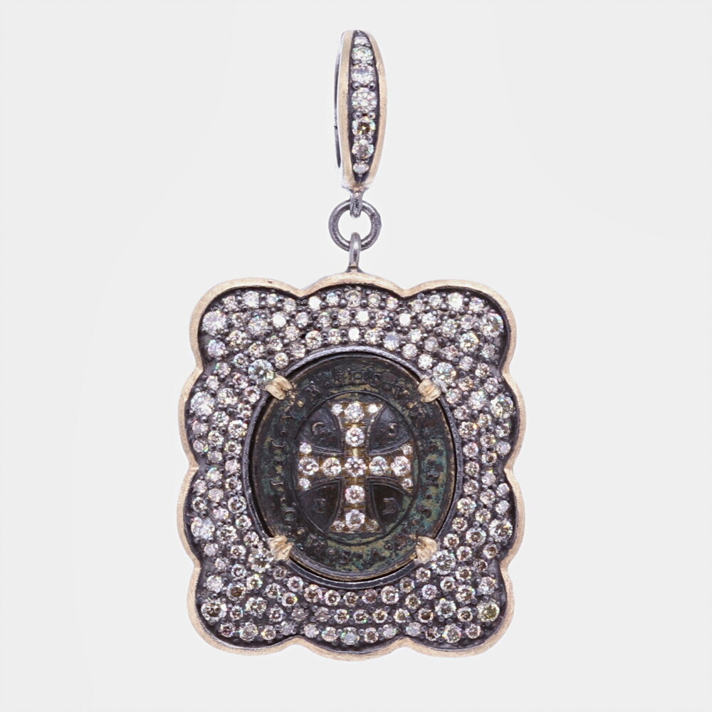 There is indeed no medal which possess such a wonderful power and protection from evil. On one side, the medal has a cross, the sign of our redemption, the protection shield given to us by God to ward off evil spirit. At the top of the cross usually stands the word PAX (peace) of the monogram HIS (Jesus). Vertically & Horizontally the letters CSSML & NDSMD mean: May the holy Cross be the light, let not the dragon be the guide. This ancient St. Benedict medal has been set inside a Diamond 2.2 tcw and 14k Yellow Gold bezel 3.39g. The bale has a 4mm opening. Antique Spanish St. Benedict medal with a champagne diamond inlay crown, surrounded by a champagne diamond, yellow gold and black rhodium bezel, having from a champagne diamond, yellow gold and black rhodium openable bale. Ancient St. Benedict Shield Medal Pendant