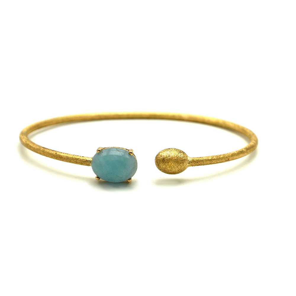 This beautifully bold 18K yellow gold bangle bracelet brought to you by Nanis Fine Jewelry and Italian designer Laura Bicego brings sheer luxury. It features an open wire design with a gold ball at one end and a smaller Aquamarine oval cabochon at the other end. Dancing In The Rain Small Aquamarine Wrap Bangle Bracelet