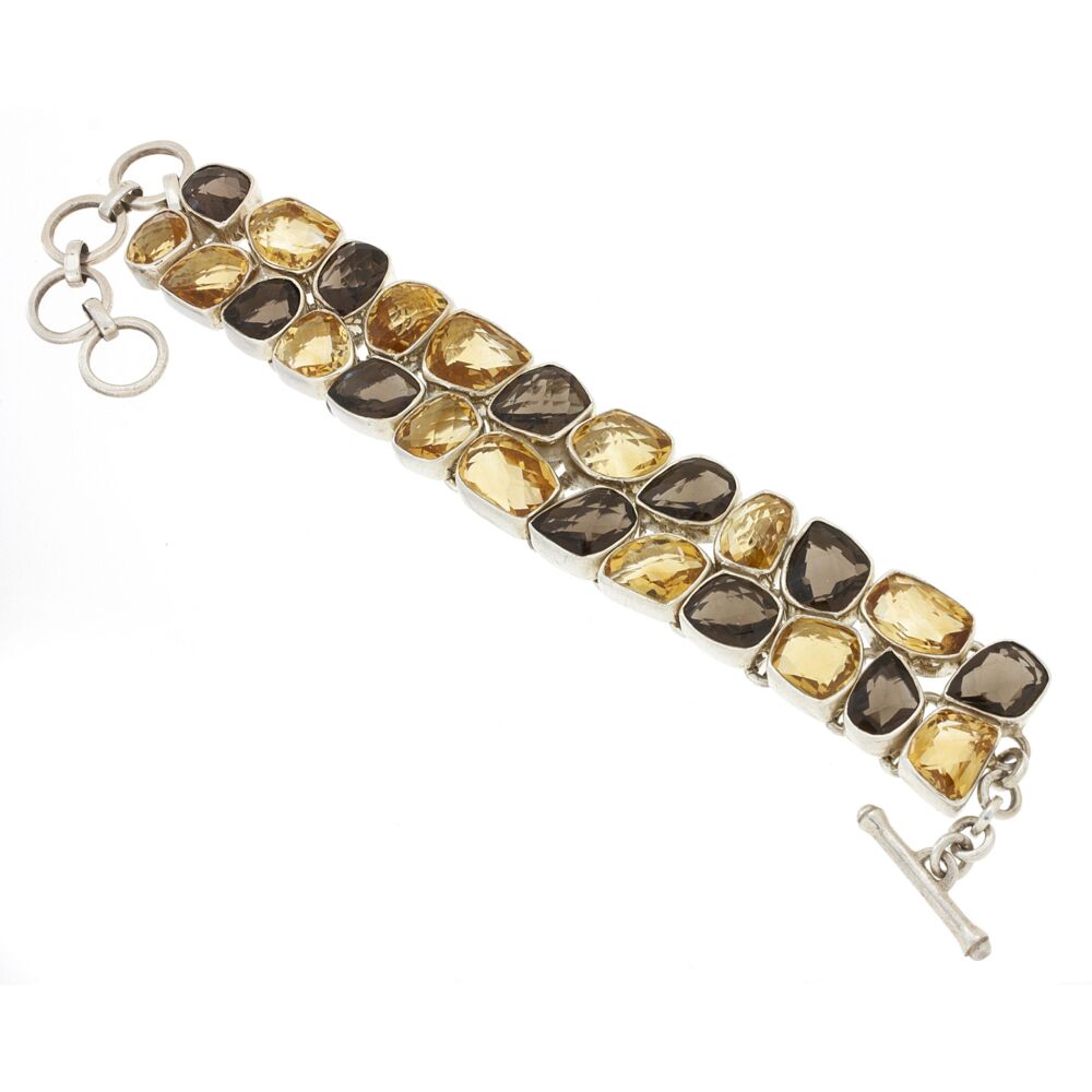 <font size="4"><span style="font-family: "EB Garamond";"><font size="4">Fourteen abstract-shaped Golden Citrine and eleven Smoky Quartz, all Checker-Board Faceted and Bezel Set in .925 Sterling Silver are Piece Linked Together in a two- row pattern with random alternation of Gemstones. The toggle-closure style makes it a user-friendly go to!</font></span></font> Citrine & Smoky Quartz Bracelet Faceted