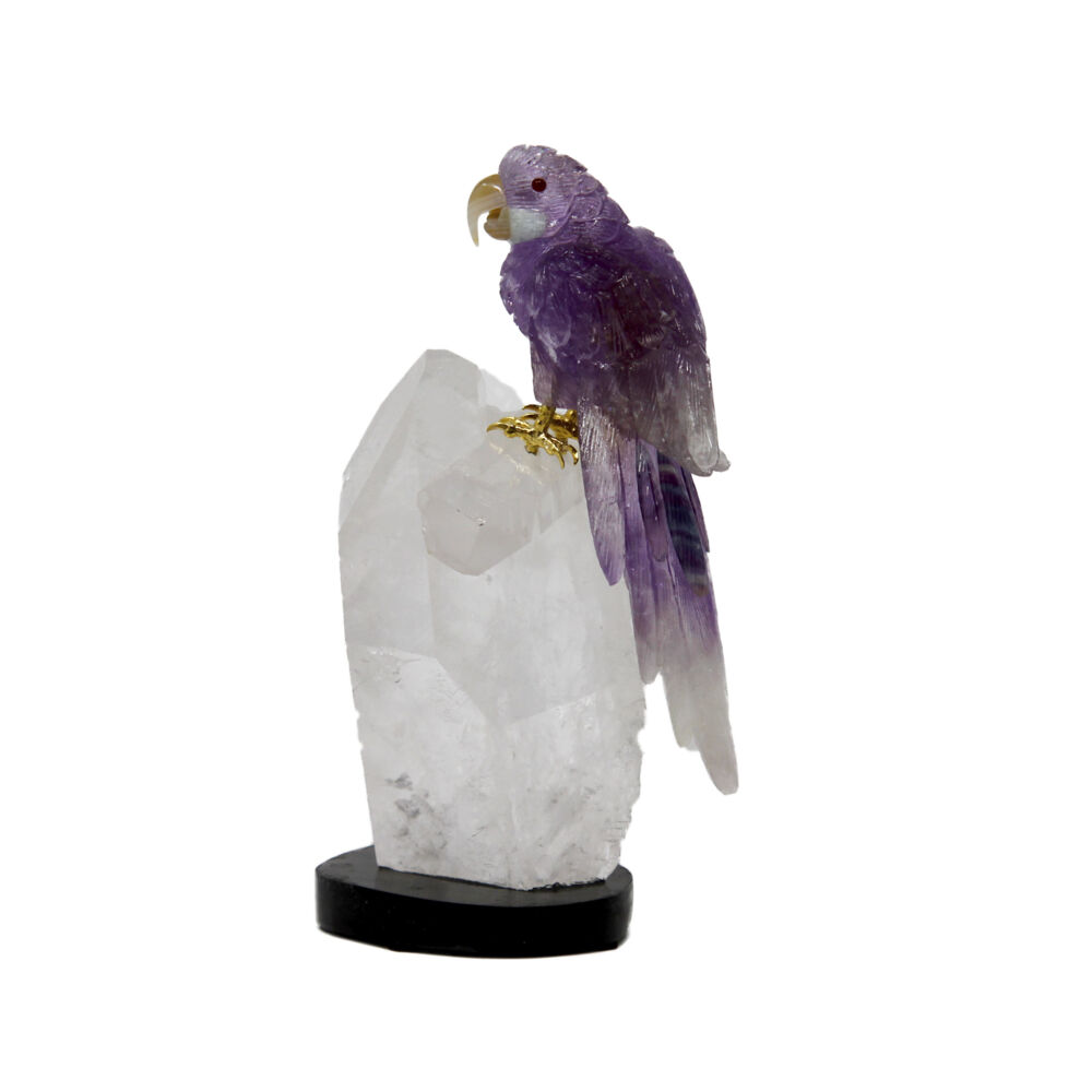 <span></span><span style="font-family: Quicksand;">Hand-carved amethyst Macaw perched atop a clear sparkling quartz crystal cluster on a black onyx base. The finite carving details of the amethyst Macaw, with its contrasting butterscotch amber beak, are astounding. The gemmy color of the carved amethyst and water-clear allure of the quartz cluster is so astounding they will call for your eye from a distance. A must have for any mineral, art, or bird collector.</span> Amethyst Macaw On Quartz Point Cluster #D028
