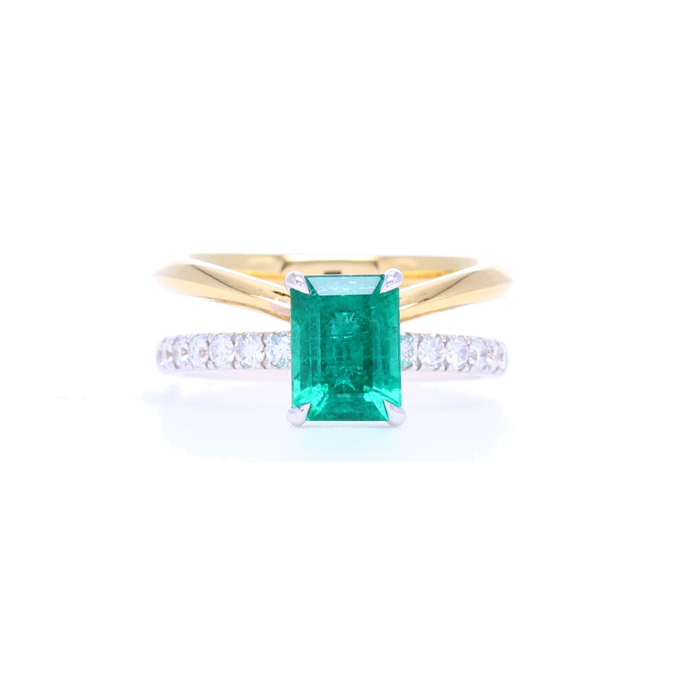 This elegant emerald cut 1.58 carat Zambian Emerald split shank ring with one pave band has such a unique design. Handcrafted in Italy and designed in NYC, this ring is stunning and comfortable. This ring contains .36 carats of diamonds which are set down the shank. 18k Yellow Gold Emerald Cut Zambian Emerald Ring with Split Diamond Shank Band