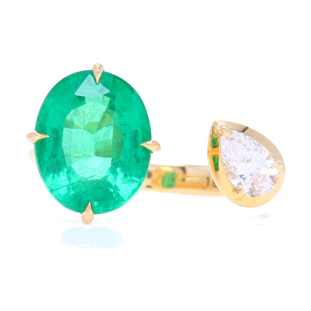 This 3.47 carat Zambian Emerald Split Ring with .32 diamond carat weight is comfortable enough to make your every day right hand ring. Set in 18k yellow gold by Valani, it's Italian craftsmanship is what you'd expect for such a stunning gemstone. We love this contemporary spin on an emerald ring, stop on in to try on a variety of different Valani rings. Open Front Split Emerald and Diamond Ring Set in Yellow Gold