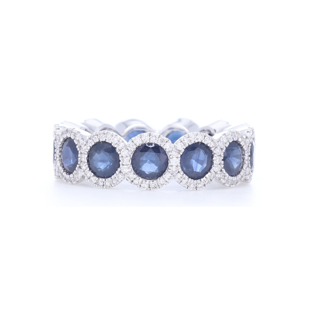 18k white gold eternity ring. Each round blue sapphire is surrounded with white diamond halos in this stunning eternity band you don't see everywhere. Celebrate a September birthday for yourself or a loved one - or just celebrate the love of blue. 18k White Gold Diamond Halo Set Round Blue Sapphire Eternity Ring