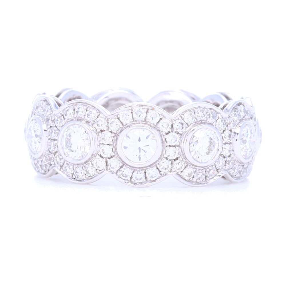 This 2.58 carat diamond eternity ring with halo pattern around round diamonds gives this ring a unique spin on the traditional eternity band. Stack this up or wear on it's own, it's incredibly comfortable yet substantial with diamond weight being packed into a slim profile. Set in 5.76 grams of 18k white gold, this ring feels luxurious and gold wasn't skimped on in the hand crafting of this piece. Stop on in to try on in store or reach out for more info. 18k White Gold Halo Set Brilliant Cut Diamond Eternity Ring