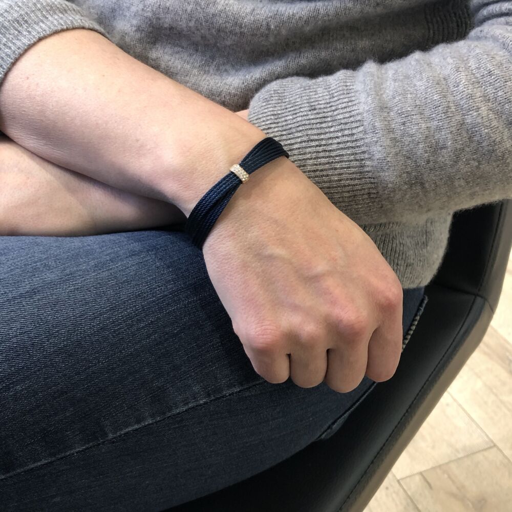 This blueberry colored heated steel cable features an 18k Rose Gold diamond station displaying a total carat weight of 0.16. This bracelet is perfect to stack with others, or wear it alone for a simple chic look. Blueberry Multi-Strand Crossed Bangle
