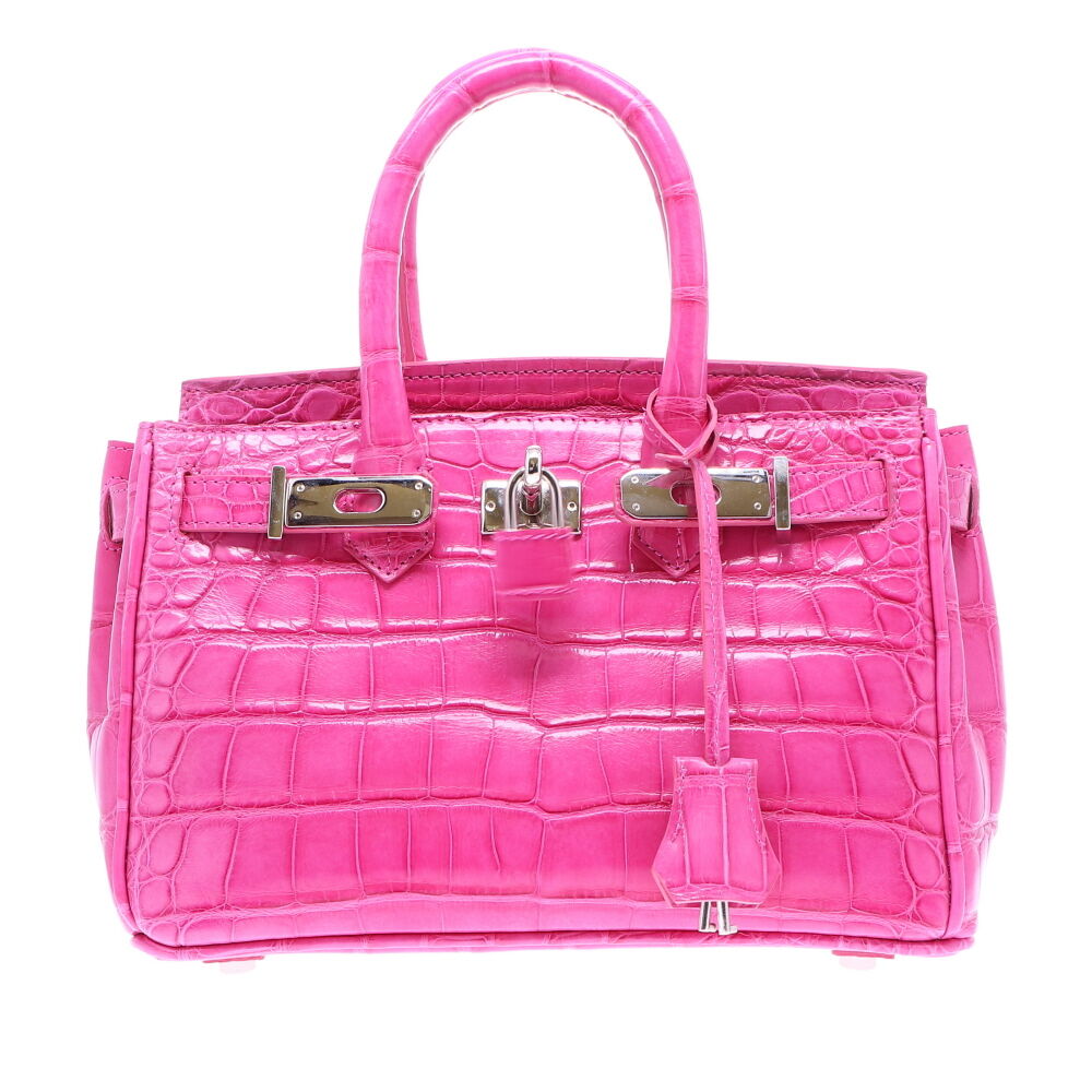 LaNae’s Anna 25 is a top handle bag made of genuine American Alligator leather. Proudly handcrafted in the USA by 3rd generation artisans, all edges are hand painted, interior is garment suede and is detailed with Italian palladium hardware. Each luxury bag may be fastened and locked with a key. The coordinating tassel and key may be removed. Each luxury bag is one of a kind and especially made for you to stand out against the crowd! Pink Alligator Classic - 25