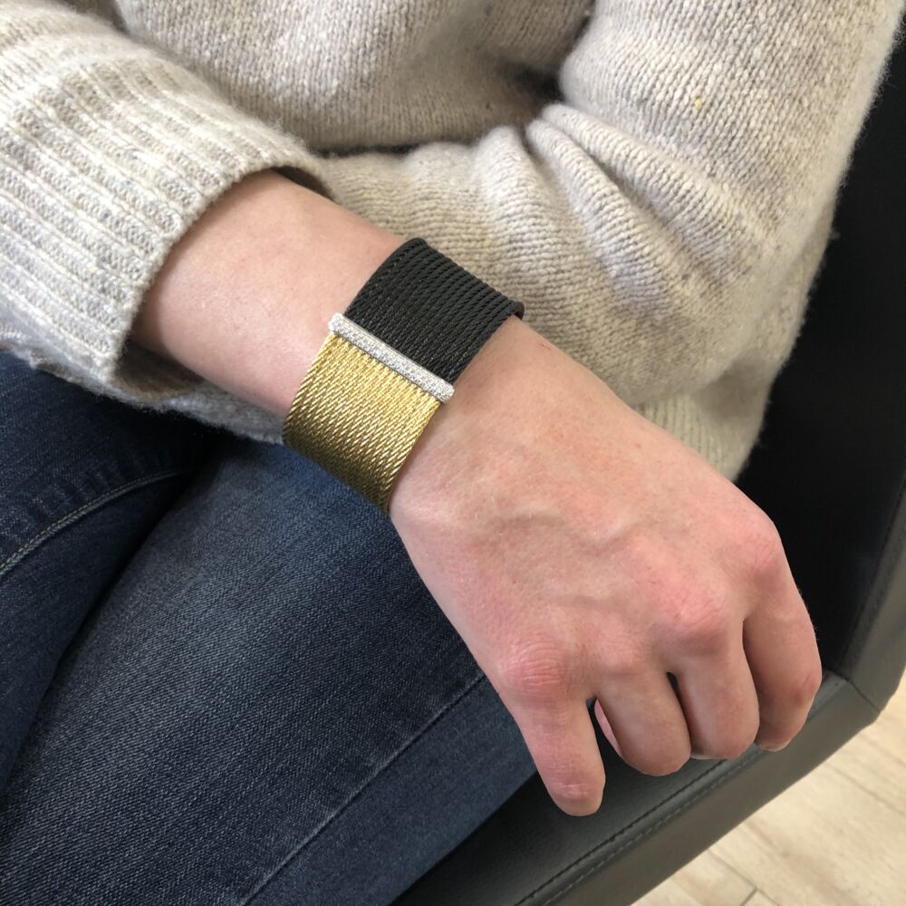 This heat treated two toned noir and yellow colored steel cable cuff features a large 18k white gold diamond bar station, displaying a total carat weight of .56 carats. This everyday cuff is comfortable enough to be worn throughout the day, and stylish enough to transition into the night. Noir Two Tone Cuff