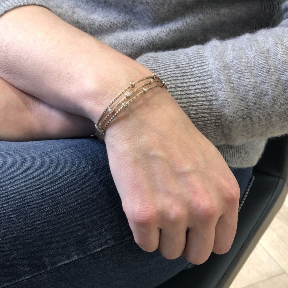 This carnation colored heat treated steel cable features a triple strand connected mid way down the bracelet. Displaying eight 18k rose gold, round diamond stations with a total carat weight of .18 carats. This bracelet is perfect to stack with others or to just wear alone. Carnation Small Constellation Bracelet
