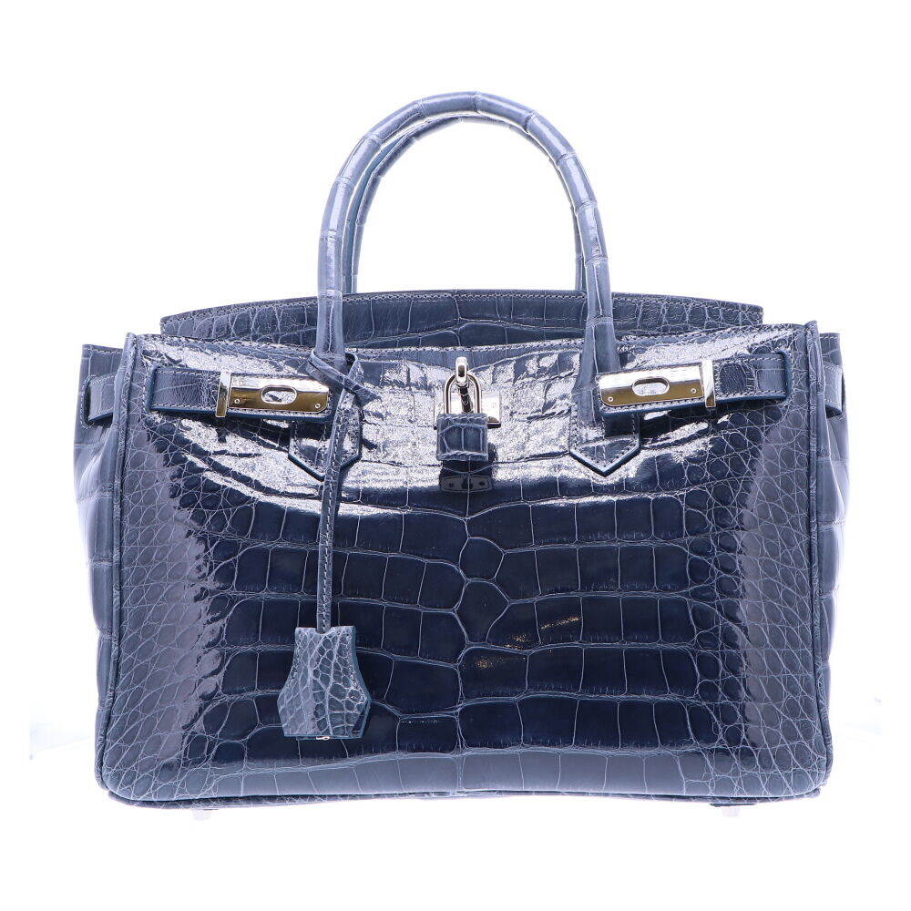 Genuine American Alligator Skin Satchel with a Premium High Gloss Finish in Slate Blue. The interior of the bag is finished with a light grey garment quality suede, and features a large zipper compartment, and two small open pouches. Italian Palladium Hardware, and four white gold plated feet. Classic 30 Slate Blue Alligator